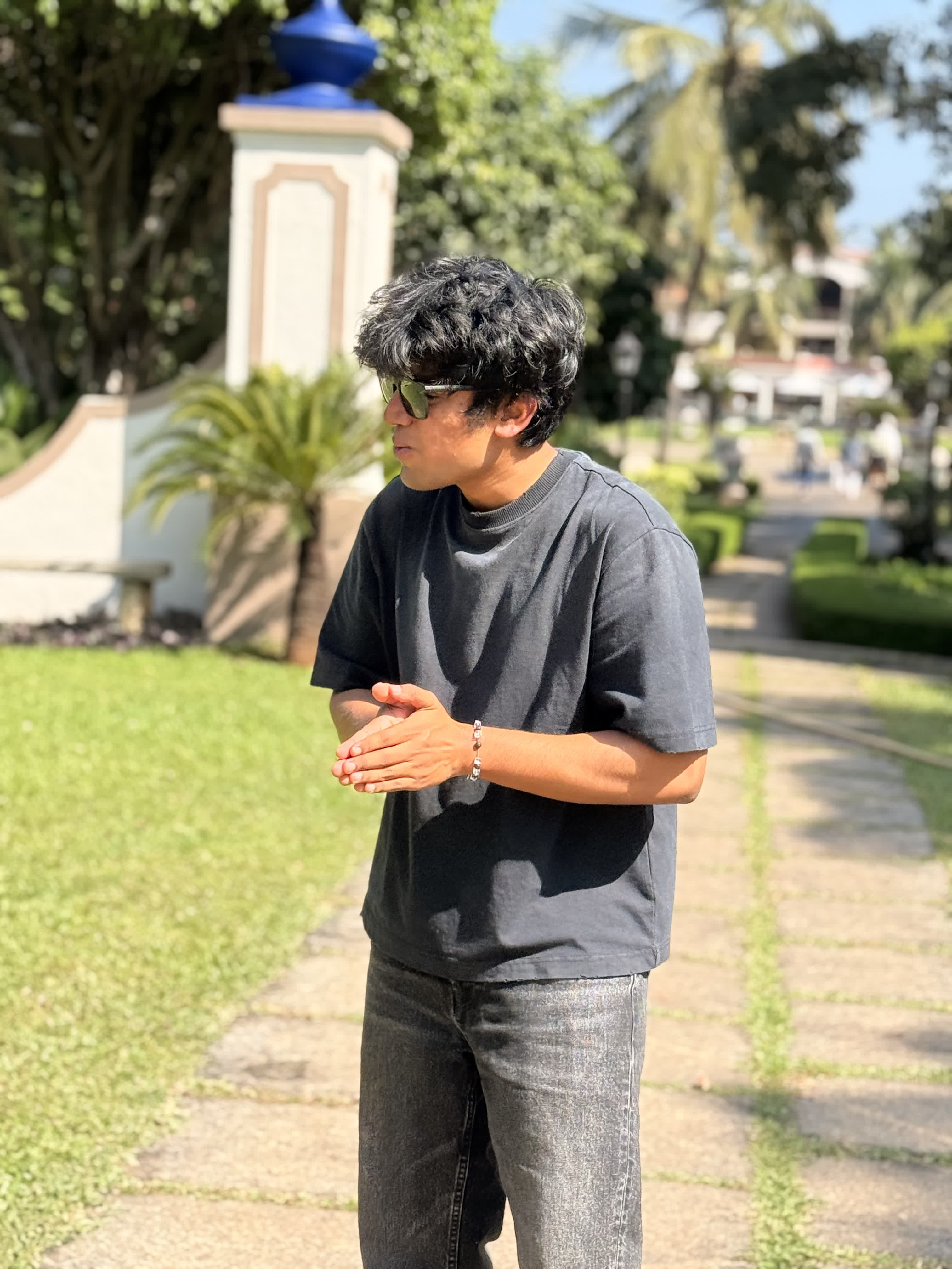 Portrait in a sunlit Goan garden in sunglasses