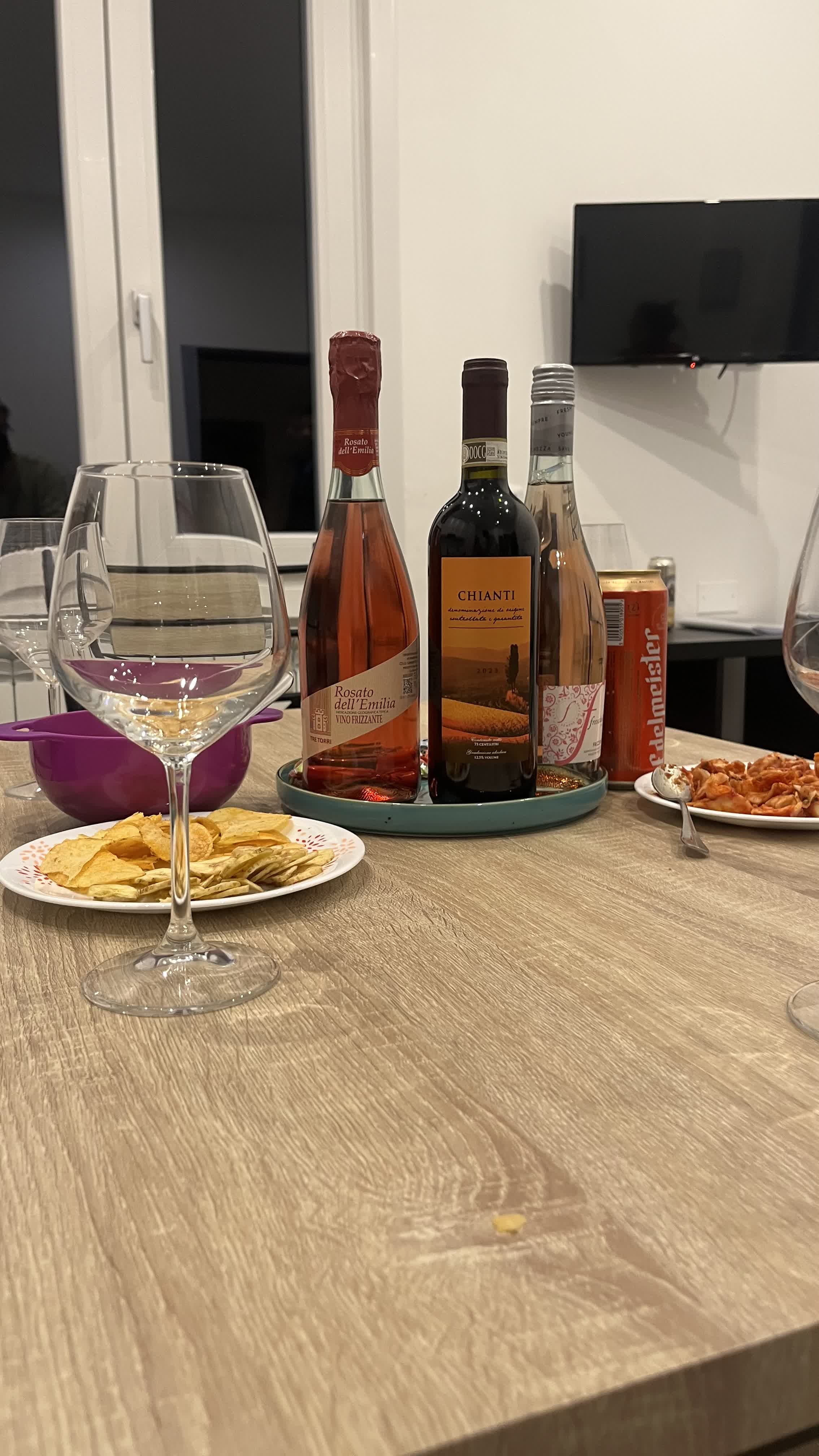 Bottles of Italian wine and snacks on a table at night
