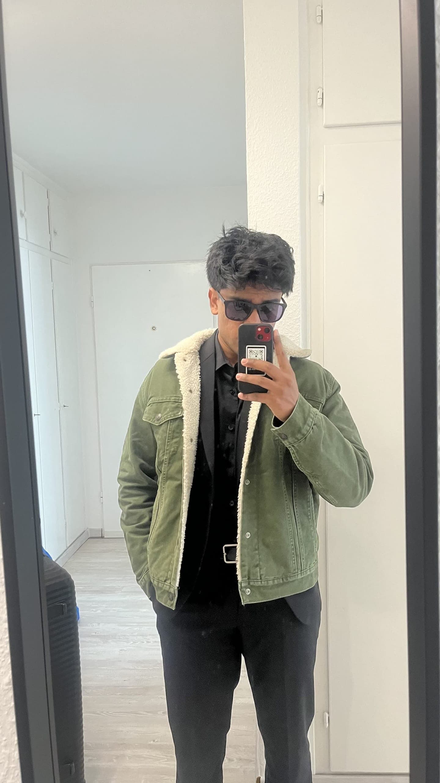 Mirror selfie in a sherpa-lined green jacket and sunglasses